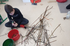 Chlapec stříhá větve na menší.