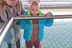 Chlapec s paní asistentkou na vlakovém nádraží.