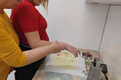 Dívka s paní asistentkou vykrajuje v listovém těstě.