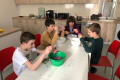 Žáci obírají šeřík do mís.