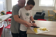 Chlapec s panem asistentem  krájí citron.