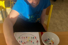 Chlapec trénuje jemnou motoriku a barvičky.