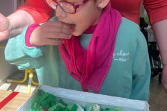 Dívka plní úkol s krabicí plné hmatových předmětů.