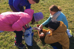 Paní učitelka s žáky chystají květináč.