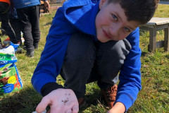 Chlapec má v ruce semínka.