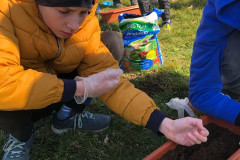 Chlapec má v ruce semínka.