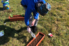 Chlapec zalévá květináč.