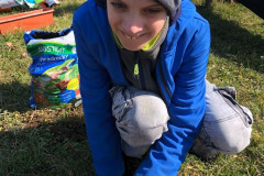 Chlapec dává semínka do květináče.