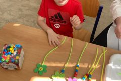 Chlapec navléká korálky podle čísel.