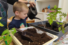 Chlapec zalévá sazeničky.