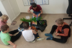 Paní učitelka ukazuje žákům rostliny.