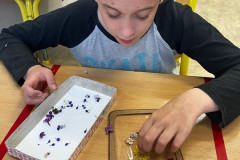 Chlapec dává kvítky na výtvor.