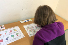 Dívka plní úkol v lavici.