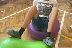 Chlapec v tělocvičně na gymballu.