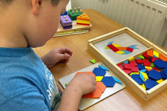 Chlapec skládá dřevěné tvary.