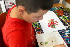 Chlapec tvoří podzimní listí.