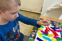 Chlapec tvoří barevný výkres.