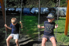 Chlapci na dětském hřišti na houpačkách.