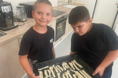 Chlapci s upečenou dobrotou na plechu.