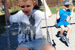 Chlapci na dětském hřišti na houpačkách.