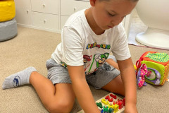 Chlapec pracuje se dřevěnou vkládačkou.