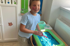 Chlapec si hraje s kynetickým pískem.