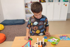 Chlapec pracuje se dřevěnými vkládačkami.