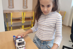 Dívka si hraje s autíčkem.