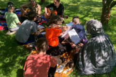 Zpívání a hraní na kytary v trávě.