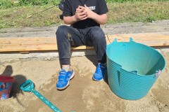 Chlapec si hraje na pískovišti.