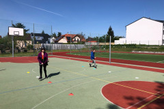 Žáci běží slalom s koštaty.