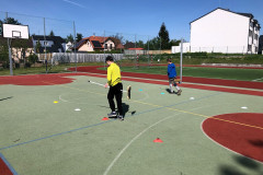 Žáci běží slalom s koštaty.