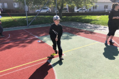 Chlapec běží slalom s koštětem.