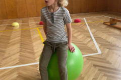 Chlapec skáče na balónu v tělocvičně.