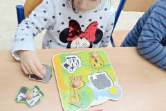 Dívka pracuje se dřevěnou vkládačkou.