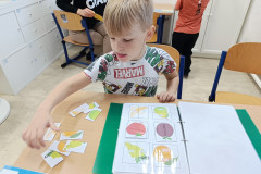 Chlapec plní úkol na zalaminovaném listu.