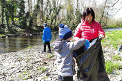 Chlapec dává odpadky do pytle.