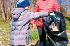 Chlapec dává odpadky do pytle.