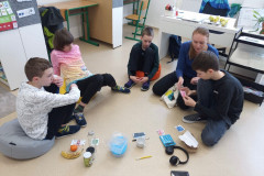 Paní učitelka v kruhu se svými žáky probírá třídění odpadků.