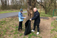 Chlapec dává odpadky do pytle.
