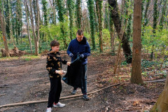 Chlapci dávají odpadky do pytle.