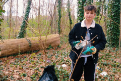 Chlapec dává odpadky do pytle.