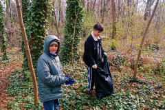 Chlapci dávají odpadky do pytle.