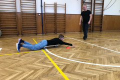 Chlapec v tělocvičně jezdí na pojizdné desce.