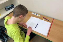 Chlapec pracuje v lavici.