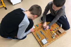 Žáci si hrají s manipulační deskou.