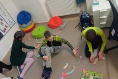 Žáci si hrají s dřevěnou vláčkodráhou.