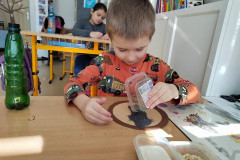 Chlapec v lavici pracuje se semínky maku.