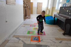 Chlapec na školní chodbě skáče panáka.