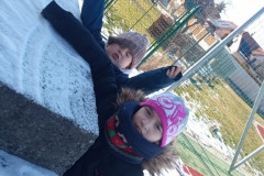 Žáci si na školním hřišti hrají se sněhem.